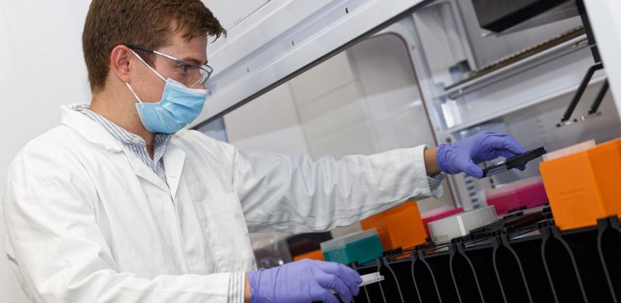 Male researcher in PPE and labcoat working in CMD lab